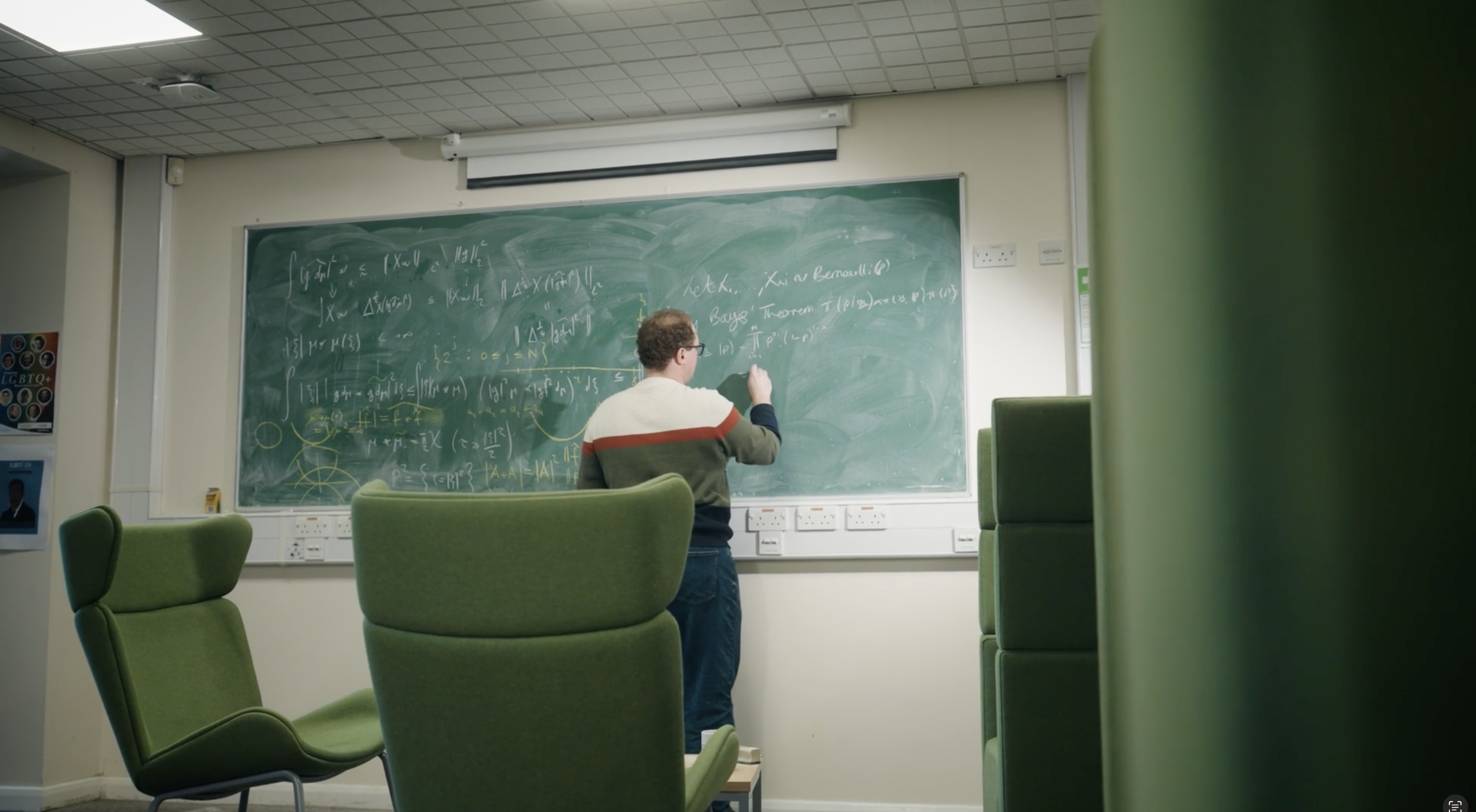 Rowland Seymour writing on a blackboard